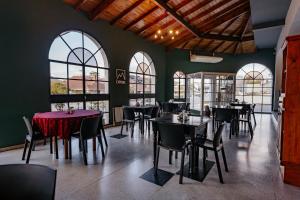 a dining room with tables and chairs and windows at Apart Hotel Explora Tandil in Tandil