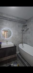 a bathroom with a sink and a tub and a mirror at Апартамент in Osh