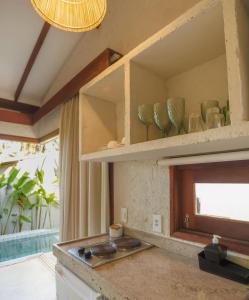 a kitchen with a stove and some vases on shelves at Villa Mar Milagres - bangalôs de luxo em São Miguel dos Milagres, Alagoas in São Miguel dos Milagres