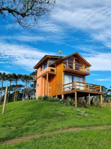 a house on top of a grassy hill at Cabana Araucária in Bom Retiro +44 photos
