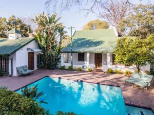 a house with a swimming pool in front of it at Rivonia Garden Suites in Johannesburg