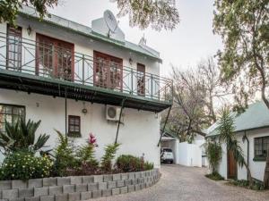 a white building with a balcony on top of it at Rivonia Garden Suites in Johannesburg