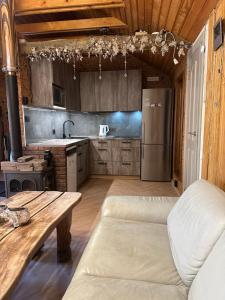 a kitchen with a couch and a refrigerator at Sodyba Ciciriai in Vėdariai