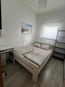 a small bedroom with a bed and a desk at Salty Paws Medveja in Medveja