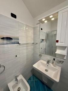 a white bathroom with two sinks and a mirror at Villa Gjoni in Kalmet