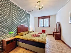 a bedroom with a bed and a table with a lamp at Maison Anny Janny - De Panne in De Panne
