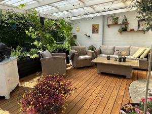 a patio with a couch and chairs and a table at Familievenligt hus med rolig have in Haderslev
