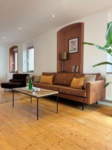 a living room with a brown couch and a table at Holistic Home Ökologisch-Biologisch-Philosophisch in Höhr-Grenzhausen