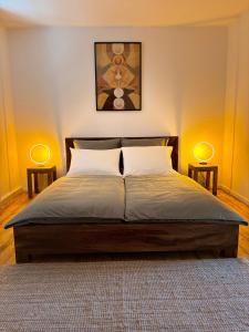 a bedroom with a bed with two lamps on both sides at Holistic Home Ökologisch-Biologisch-Philosophisch in Höhr-Grenzhausen