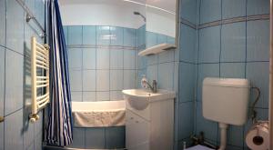 Un baño con azulejos azules, inodoro y lavabo. en Charming flat near Black Sea, en Constanţa 7 fotos más