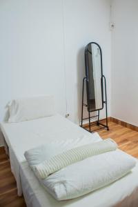a white bed with a mirror in a room at Casa de férias de Jamal em Chimoio in Chimoio