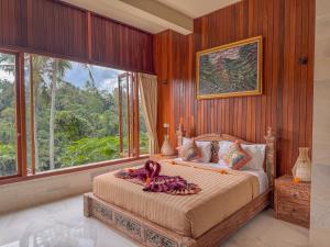 a bedroom with a large bed with wooden walls and windows at Made Punias Jungle Paradise in Ubud +204 photos