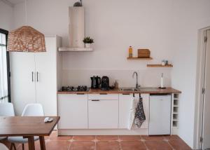 a kitchen with white cabinets and a wooden table at La casa Zamora in Totana