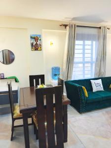 a living room with a green couch and a table at Laimum 1br Milimani Zero700One4422Eight in Kisumu