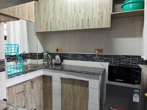 a kitchen with wooden cabinets and a counter top at Laimum 1br Milimani Zero700One4422Eight in Kisumu +11 photos