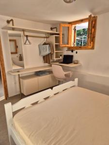 a bedroom with a bed and a desk and a window at Vacation Unit - Private Terrace, Steps from Sea in Isthmia