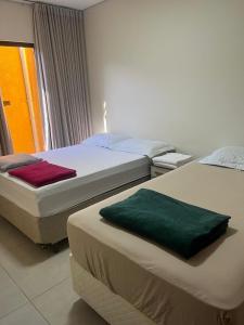 two beds sitting next to each other in a bedroom at casa nova no guara proxima ao aeroporto in Brasilia