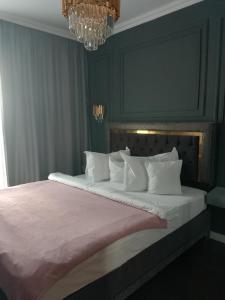 a bedroom with a large bed with white pillows at Gloria Golden Suite- Luxury&Designe Experience in Oradea