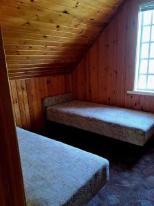 a room with two beds in a wooden cabin at Basanavičiaus kambarelis in Palanga