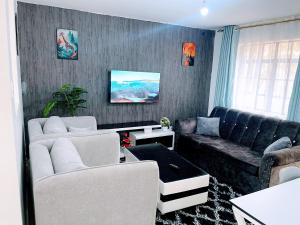 a living room with two couches and a couch at Elegant One Bedroom Apartment - Athi River - Kesit Anga in Athi River