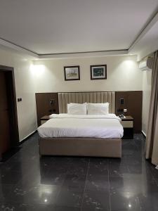 a bedroom with a large bed and two night stands at The Safehouse in Enugu