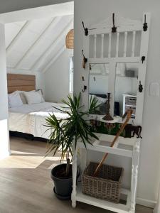 a bedroom with a bed and a potted plant at 35 On the Run in St Francis Bay