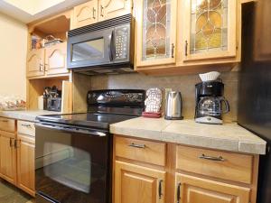 a kitchen with a stove and a microwave at 61 Jabberwocky Home by Stay Winter Park in Fraser +28 photos