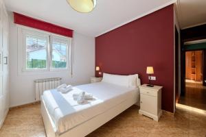 a bedroom with a white bed and a red wall at La Ballena Beach by Next Stop Bilbao in Castro-Urdiales +40 photos