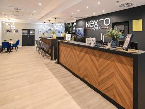 un restaurante con un mostrador de recepción y una barra en NEXTO DORMERO Hotel Budapest, en Budapest
