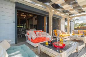 a patio with couches and a table on a deck at Villa des Rochers in Saint-François