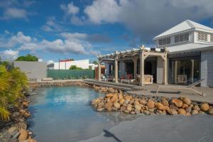 a house with a swimming pool next to a building at Villa des Rochers in Saint-François