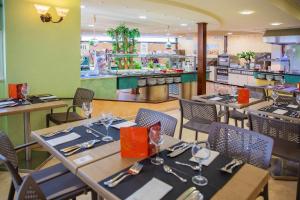 a dining room with tables and chairs in a restaurant at Hotel Servigroup Rialto in Benidorm +25 photos