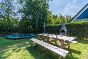 a picnic table and a trampoline in a yard at Hoogelandt 126 in De Koog