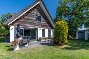 a home with a patio and a house at Hoogelandt 126 in De Koog