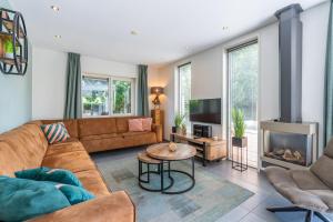 a living room with a couch and a fireplace at Hoogelandt 126 in De Koog