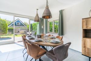 a dining room with a wooden table and chairs at Hoogelandt 126 in De Koog