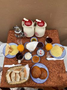 a table topped with plates of food next to two tea pots at Riad Jibril in Marrakech
