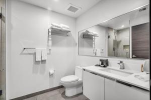 a white bathroom with a toilet and a sink at Condo with 1 Bedroom Terrace and Hot Tub in Hollywood