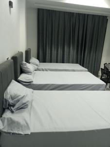 three beds in a room with a window at Mr Khaled Hotel in Siwa