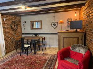 a living room with a red couch and a table at Gîte de caractère au calme , proche quartier historique, Au Merlenchanteur in Schiltigheim