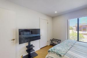 a bedroom with a large flat screen tv on the wall at At Your Leisure in Mesa