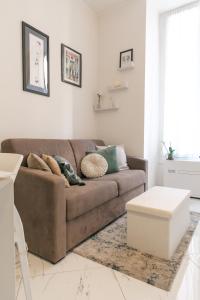 a living room with a brown couch and a table at Appartamento in Piazza Colombo a 300mt dal Mare in Sanremo
