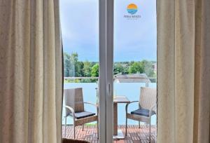 a room with a balcony with a table and chairs at Sztutowo Perła Mierzei by Grand Apartments in Sztutowo +1 photo
