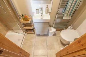 a small bathroom with a toilet and a sink at Corner Cottage in Castlerock +24 photos