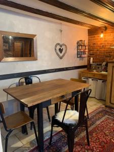a kitchen with a wooden table and two chairs at Gîte de caractère au calme , proche quartier historique, Au Merlenchanteur in Schiltigheim