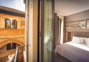 a bedroom with a bed and a fireplace at Corral del Carbón GG Luxury Hotel Boutique in Granada