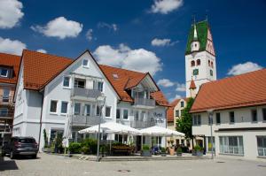 a group of buildings with a clock tower at Hotel Peterhof in Dietenheim