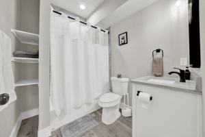 a white bathroom with a toilet and a shower at Spacious 3BR Home w Yard, Smart TV Parking in Humble +29 photos