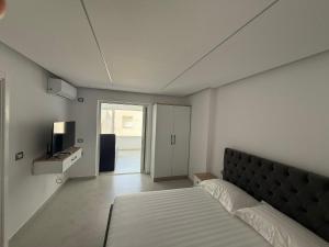 une chambre avec un lit et une télévision dans l'établissement Dashaj Rooms 302, à Ksamil