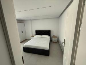une chambre avec un lit dans une pièce blanche dans l'établissement Dashaj Rooms 302, à Ksamil
